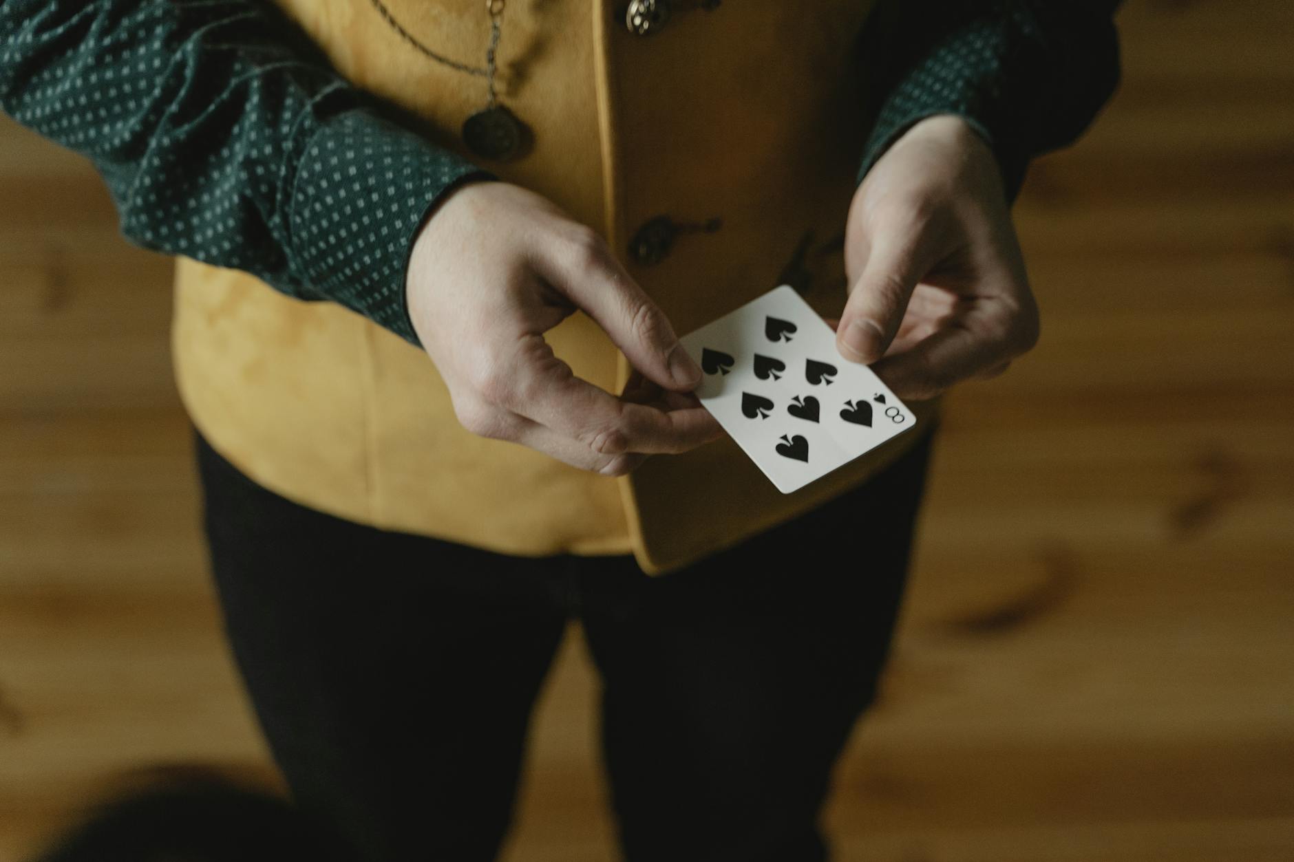 photo of a person s hands holding a playing card