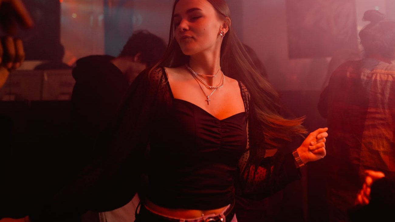 a woman in black long sleeves dancing at the club